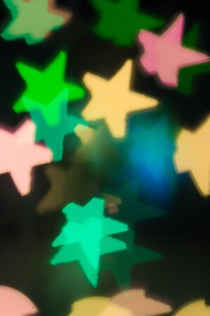 A background with colored stars for Christmas motifs, cards, congratulations on New Year and Christmasの写真素材