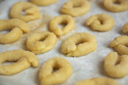 Baking tray full of small candies called anise rolls ready to go into the oven at homeの写真素材