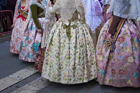 Group of women dressed in their costumes falleras regional after making the Ofrenda (floral offering) to the Virgin Mary in the Plaza de la Virgen in Valencia, Spainの写真素材