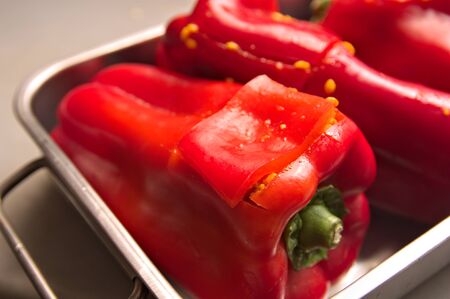 Close-up of some raw red peppers that are stuffed with rice with meat and are ready to be bakedの写真素材