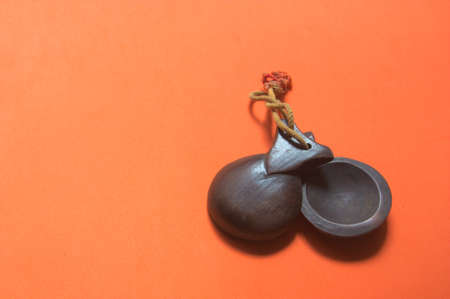 Wooden castanets typical of Spanish music, such as flamenco, las jotas, with an orange background with copy space.の写真素材