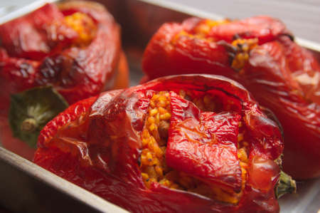 Casserole where some red peppers stuffed with rice, tomato and meat have been baked