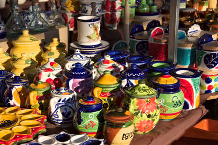 Close-up of a stall in a traditional flea market that has its ceramic containers decorated in bright colors on displayの写真素材