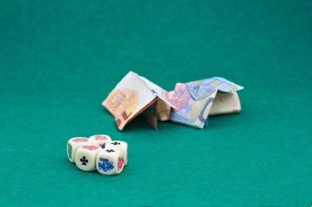 Close-up of some gambling dice where large amounts of money are bet on a green tablecloth and with...