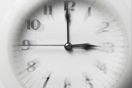 Close-up of an out of focus that indicates three in the afternoon. Conceptual image related to stress, business and appointmentsの写真素材