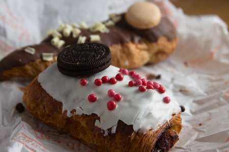 Close-up of some chocolate puff pastries, decorated with more chocolates of various colors,...
