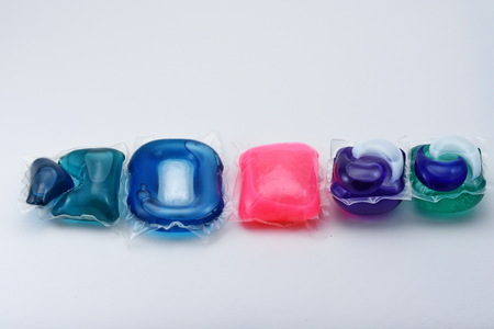 Gel capsule pods with laundry detergent on whiteの写真素材