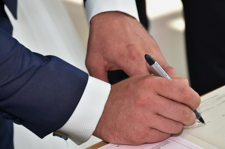 Groom signing marriage license or wedding contractの写真素材