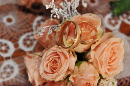 Wedding rings on a bouquet of rosesの写真素材
