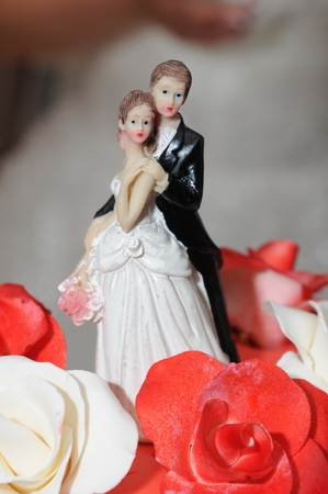 Bride and groom miniature on wedding cakeの写真素材