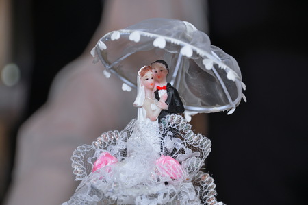 Bride and groom miniature on wedding cakeの写真素材