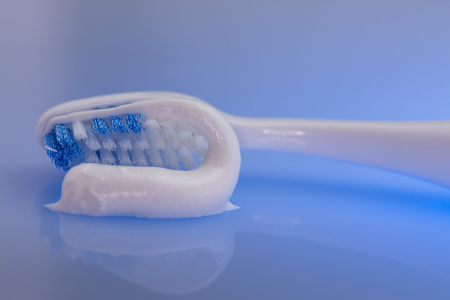 toothbrush and toothpaste on blue backgroundの写真素材