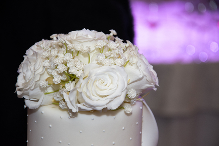 Wedding cake covered with white fondant,flowersの写真素材