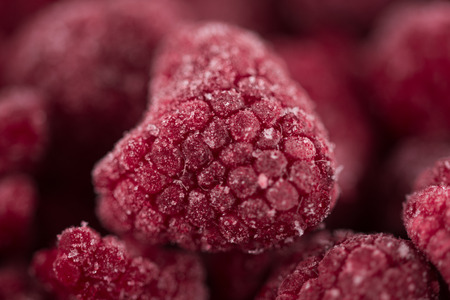 Sweet frozen raspberries on white background