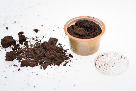Capsules for espresso coffee machine on heap of ground coffeeの写真素材