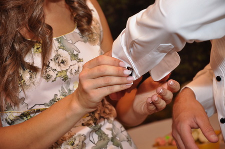 girl helps the groom to put cufflinksの写真素材
