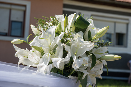 white lilies on the hood of a wedding carの写真素材