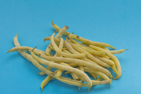 Pile of fresh green beans over a blue background