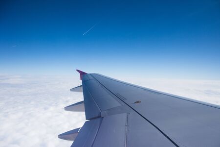 An airplane window view of wing and flaps