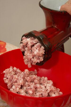 Meat grinder - process of grinding meat. Beef mince in mincing-machine. Cooking foodの写真素材