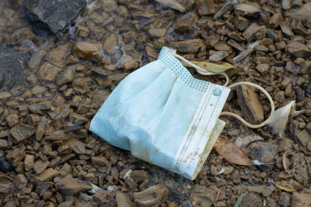 protective mask, blue face Mask thrown on the beachの写真素材