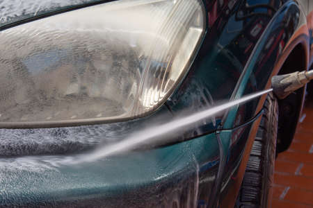 High pressure washing car outdoorsの写真素材
