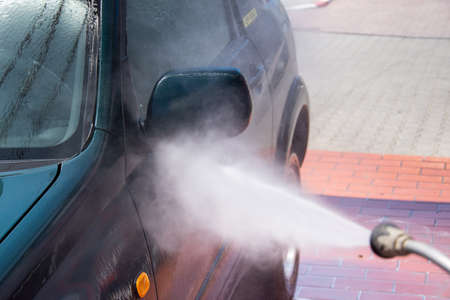 High pressure washing car outdoors