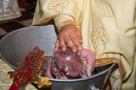 baby  baptism in Orthodox Church Romania,sinking , child in holy water during baptism