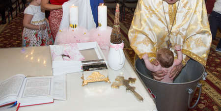 baby  baptism in Orthodox Church Romania,sinking , child in holy water during baptism
