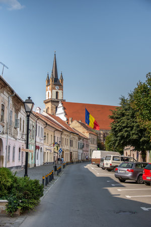 Evangelical Church Tower  in Bistrita ,august 2021,and the flag of Romania ,view from Nicolae  Titulescu streetのeditorial素材