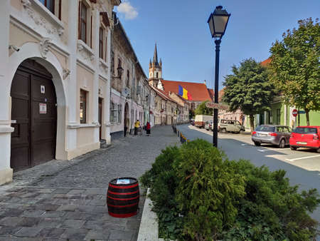 Evangelical Church Tower  in Bistrita ,august 2021,and the flag of Romania ,view from Nicolae  Titulescu streetのeditorial素材