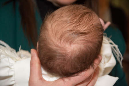 Cut off the hair from the baptism ceremony. Candle and hair as detail from baptism in Romaniaの写真素材
