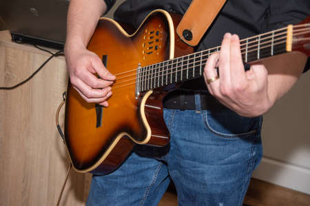 A man plays the guitar, detail