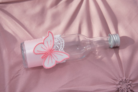 an empty bottle decorated with a pink butterflyの写真素材