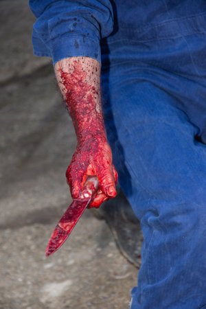 the scene of the crime, a large knife with blood in the right hand, the blood washing