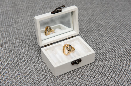 gold wedding rings in a white box with a mirror