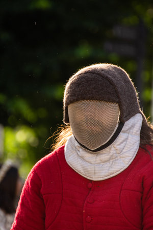 A swordsman with a protective mask on his face