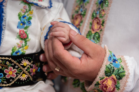 A man dressed in folk costume holding baby's hand, 2024 Romaniaの写真素材