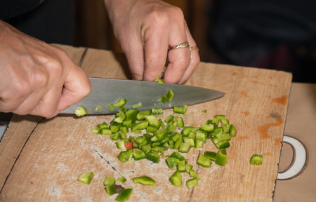 finely cutting the peppers on a wooden bellの写真素材