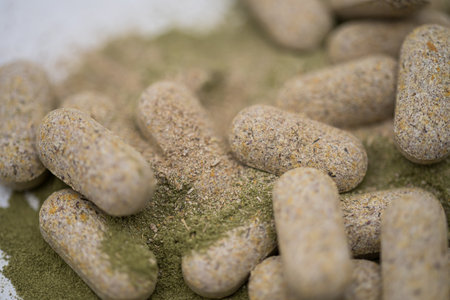Moringa powder and organic capsules on white background