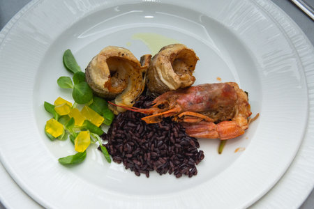 Crab with black rice, fried fish and saladの写真素材