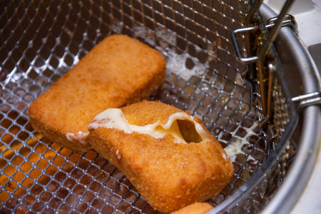 mozzarella sticks being deep  fried. Mozzarella sticks are a popular appetizer or snack made from...
