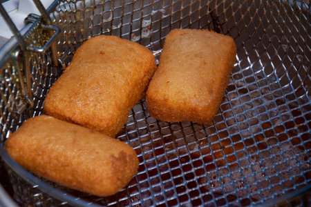 mozzarella sticks being deep  fried. Mozzarella sticks are a popular appetizer or snack made from...