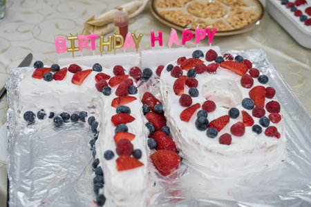 70th birthday cake, decorated with fresh strawberries, raspberries, and blueberries.の写真素材