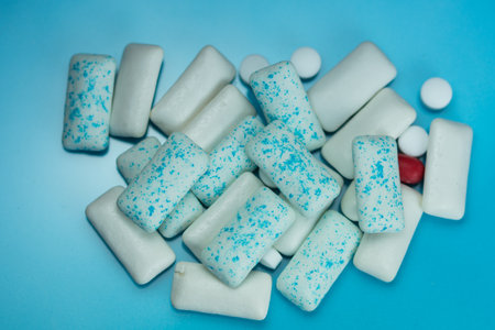 a pile of assorted, colorful chewing gum pieces. 
Chewing gum is a soft, cohesive substance designed to be chewed but not swallowed.の写真素材