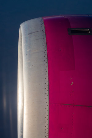 a close-up view of a commercial aircraft's engine pylon and a portion of the engine cowling, as seen from a passenger window. The pylon is the structure that mounts the engine toの写真素材