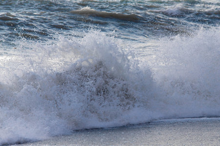 storm on the sea in the rays of sunset big waves, spray