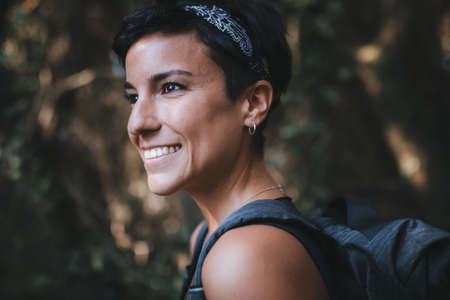 Close up portrait of a beautiful woman smiling with short hair and a beautiful smile admiring nature...