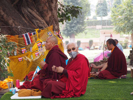 Bodhgaya, India - February 24th 2020 - Buddhist monk praying in Bodhgaya, India, wearing a maskのeditorial素材