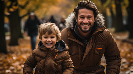 Father and son in autumn park. Happy family having fun outdoors.の素材